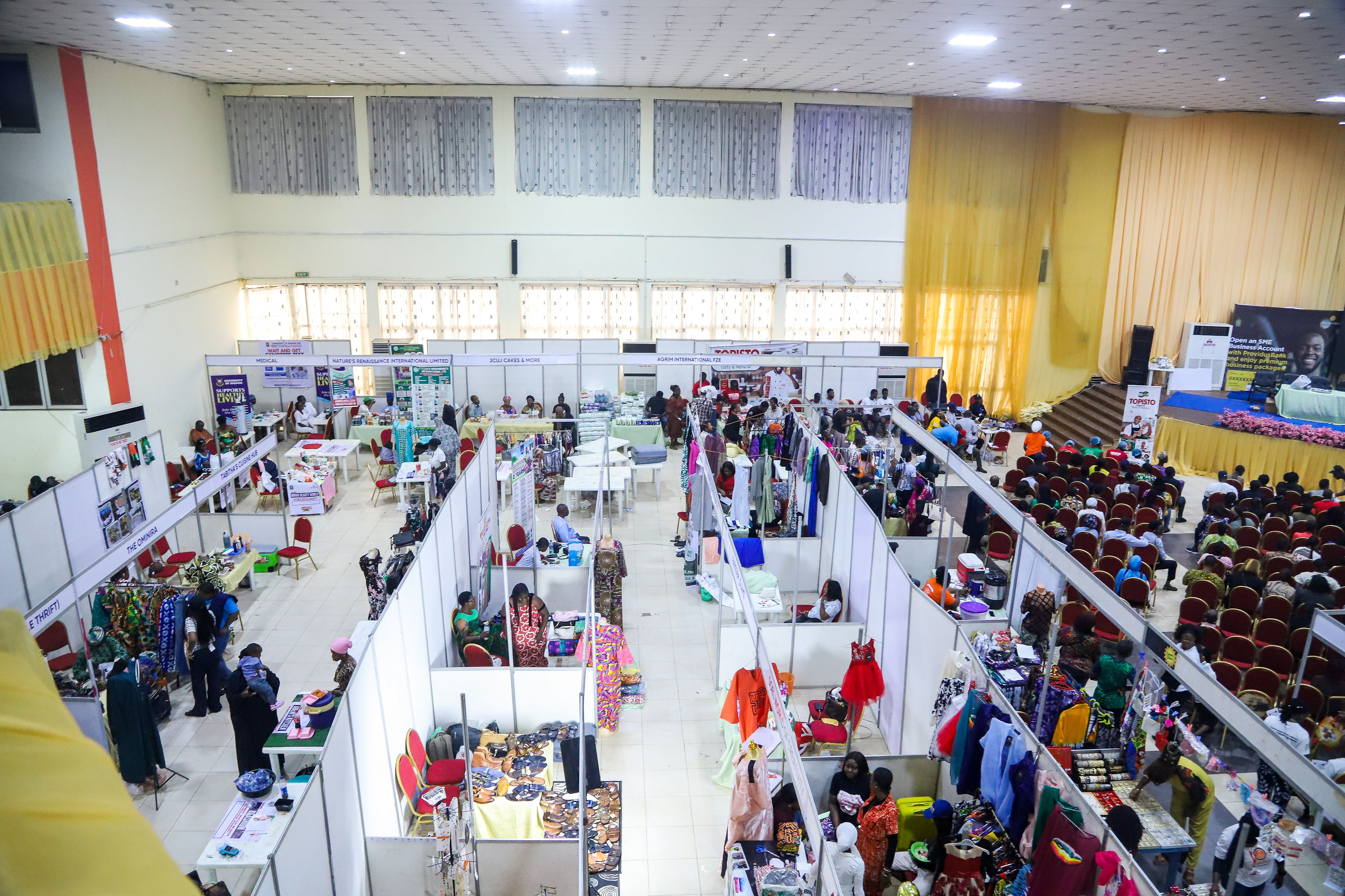 Aerial view of the packed University of Ibadan SME Fair exhibition hall showing vendor booths and attendees